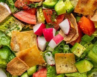 Componenti di un Fattoush: pomodori, cetrioli, ravanelli, cipolla rossa, pane pita tostato e erbe aromatiche