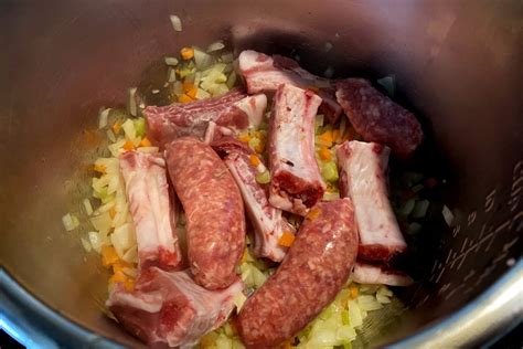 Pentola con sugo di salsiccia e spuntature in cottura
