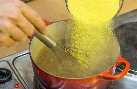Dettaglio della farina di mais che viene versata nell'acqua bollente