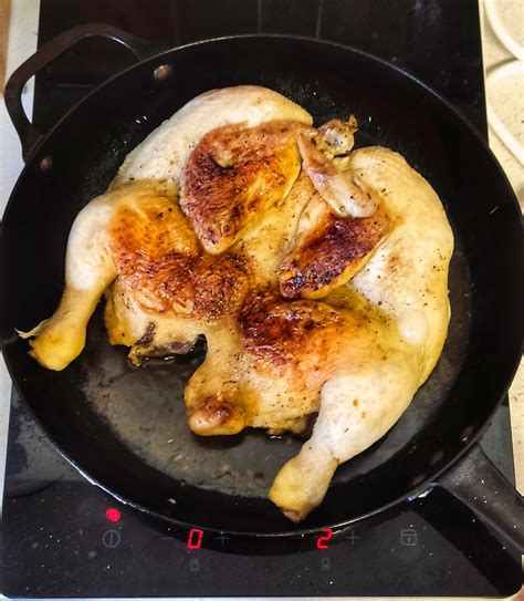 Padella di ghisa con pollo alla diavola in cottura