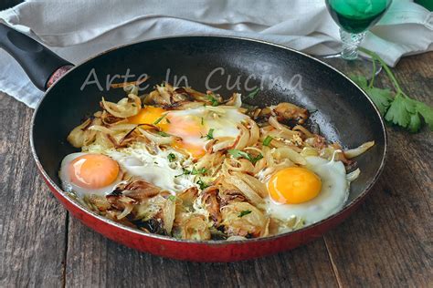 padella con uova strapazzate, wurstel a rondelle e cipolle soffritte