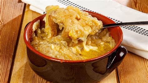 Una cocotte individuale con zuppa di cipolle pronta per essere infornata