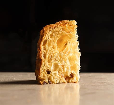 Panettone con una fetta tagliata e una ciotola di crema