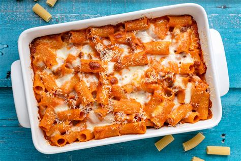 Famiglia che mangia pasta al forno a tavola