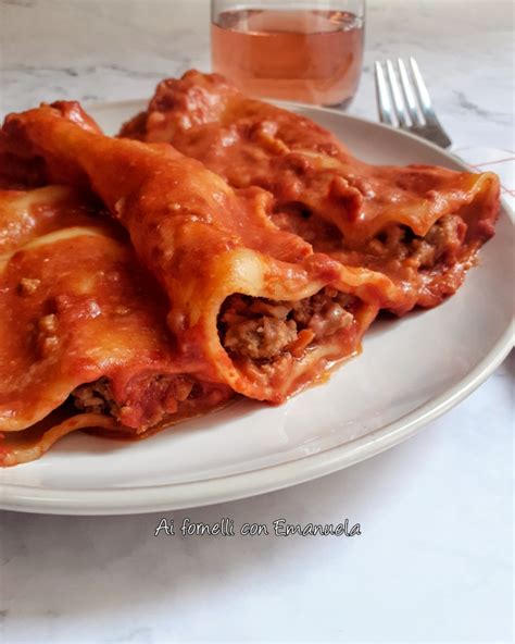 Immagine di cannelloni al forno ricoperti di besciamella e ragù, con parmigiano grattugiato