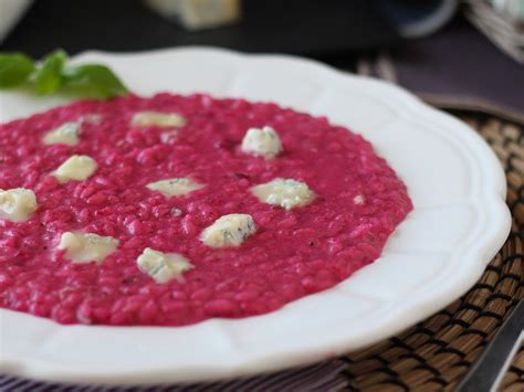 Piatto di risotto alla barbabietola e caprino decorato con erbe