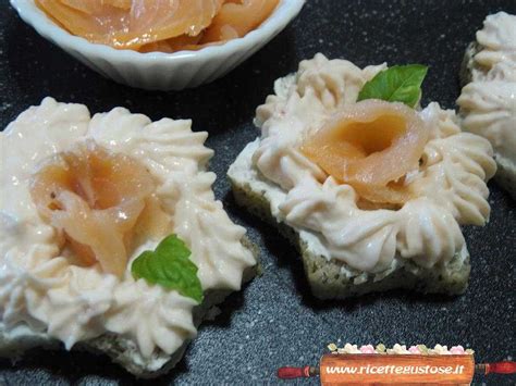 Tartine al salmone decorate con semi di papavero e fettine di limone