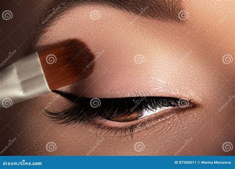 Donna che applica ombretto marrone opaco