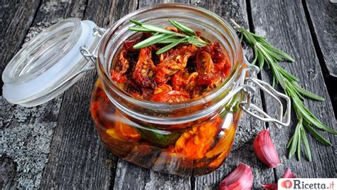 Vaso di vetro con pomodori secchi sott'olio e erbe aromatiche