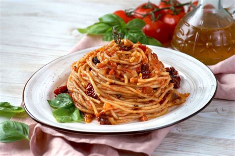 Piatto di pasta con pomodori secchi, olive e capperi