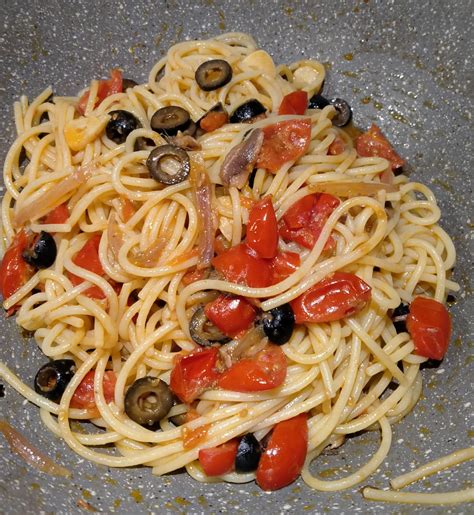 Piatto di spaghetti con acciughe e pomodorini