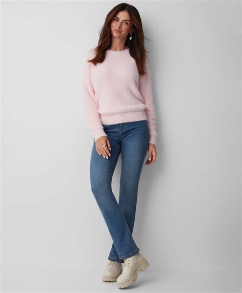 Donna che indossa un maglioncino rosa pastello con jeans