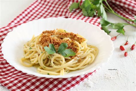 Una ciotola di spaghetti integrali con alici e pangrattato, guarniti con prezzemolo fresco