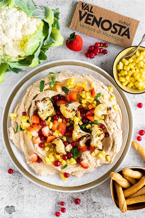 Ciotola di hummus di cavolfiore con verdure crude e pane