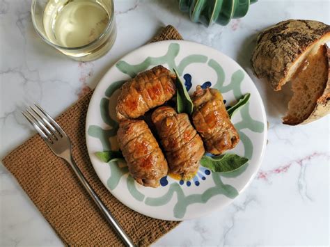 Piatto di involtini di carne serviti con contorno di verdure