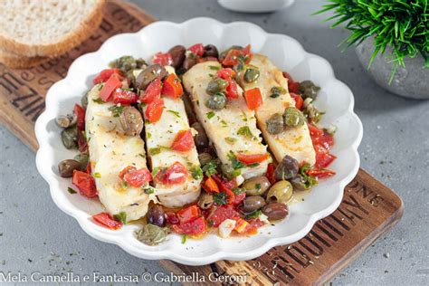 Un piatto di filetti di merluzzo alla mediterranea con pomodorini e olive