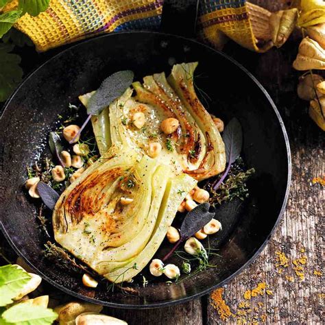Finocchi che cuociono in padella con burro e erbe aromatiche