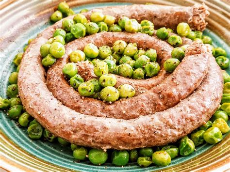 Salsiccia e piselli che cuociono in padella