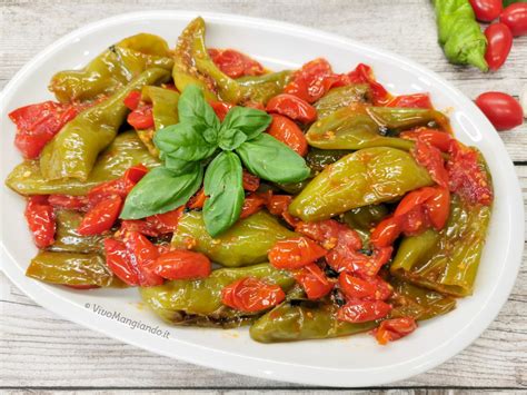 Piatto finito di friggitelli in padella con pomodorini e pane fresco