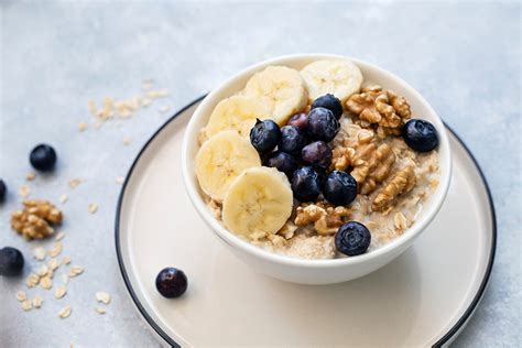 Immagine di una ciotola di porridge fumante guarnita con frutta fresca, noci e semi.