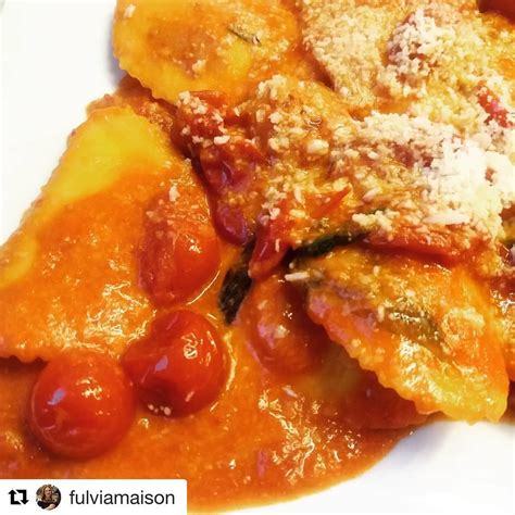 Un primo piano di ravioli conditi con salsa puttanesca e guarniti con basilico