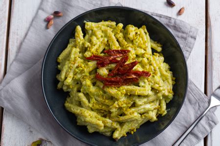 Varietà di pasta condita con pesto di rucola e pistacchi