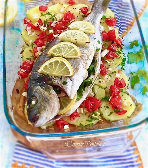 Ingredienti freschi per orata al forno: orata, patate, limone, rosmarino, aglio, pomodorini