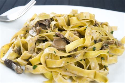 Tagliatelle con funghi porcini e panna in un piatto