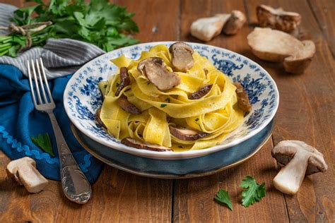 Ingredienti per le tagliatelle ai funghi porcini e panna disposti su un tavolo