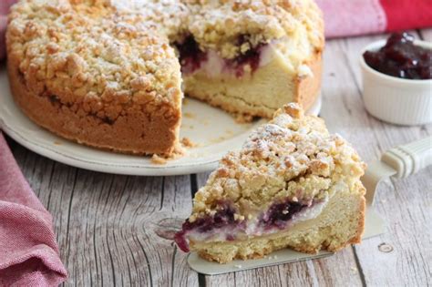 Una fetta di sbriciolata ricotta e amarene su un piatto con un cucchiaio di gelato alla vaniglia