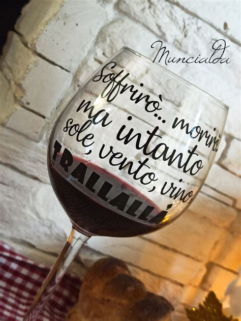 Un calice di vino con un cocktail dorato e un bordo decorato con polline