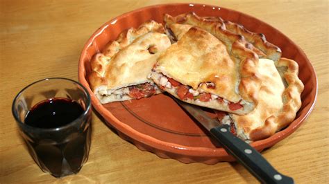 Assemblaggio a strati della Tiella in una teglia di terracotta