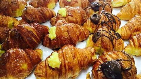Immagine di vari cornetti e croissant su un bancone di pasticceria