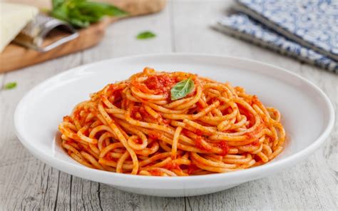 piatto di spaghetti conditi con salsa di pomodoro al forno
