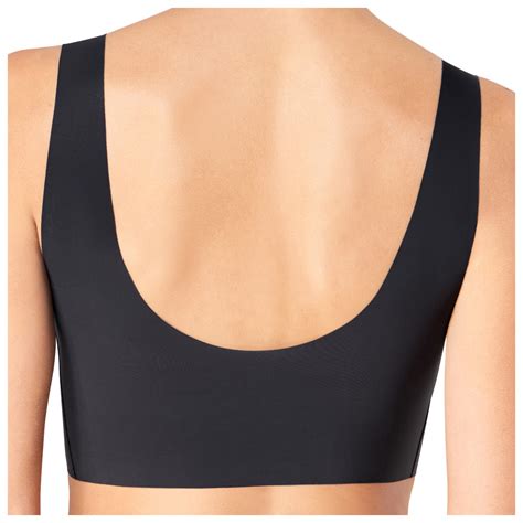 Una donna che prova diversi outfit, mostrando come il reggiseno invisibile Sloggi Zero Feel si adatti a ciascuno
