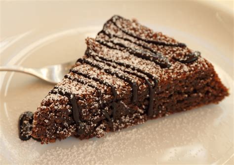 Torta di cioccolato fondente e noci spolverizzata di zucchero a velo