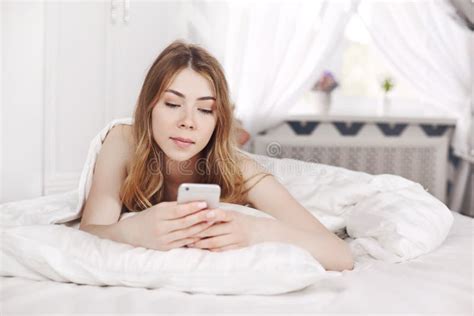 Persona che usa il telefono a letto