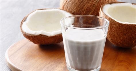 Una ciotola di latte di cocco e una di latte vaccino, con spezie curry intorno