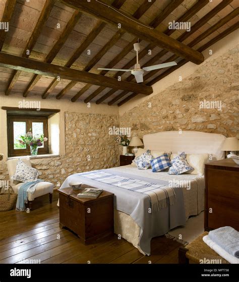 Camera da letto con travi in castagno imbiancate e pareti color blu notte