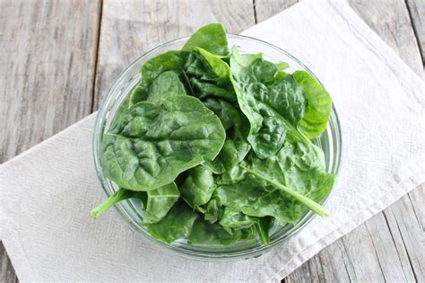 Spinaci freschi e uova in una ciotola, pronti per essere mescolati