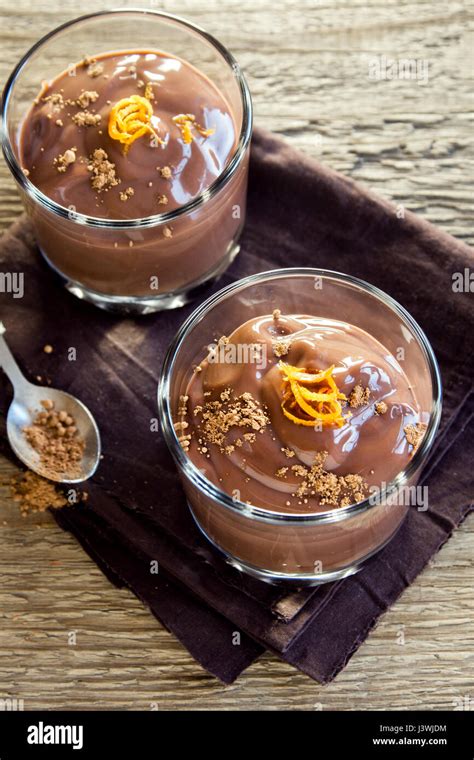 ciotola di vetro piena di mousse al cioccolato, guarnita con una fogliolina di menta
