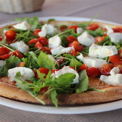 Dettaglio di una pizza con pomodorini freschi e mozzarella di bufala