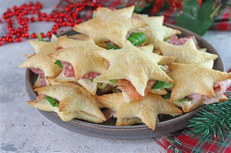 Composizione di antipasti natalizi, tra cui stelle di pasta sfoglia e frittelle