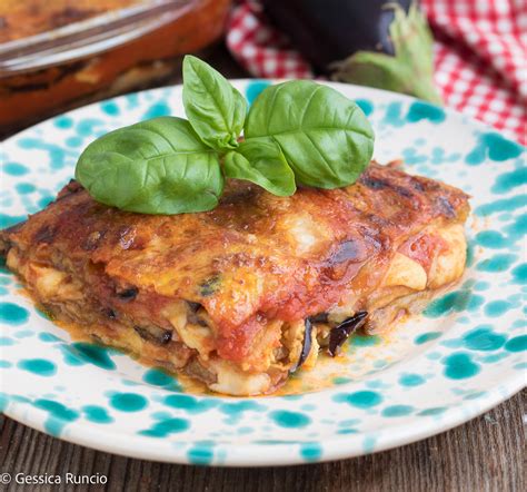 Una tavola imbandita con un piatto di parmigiana di melanzane