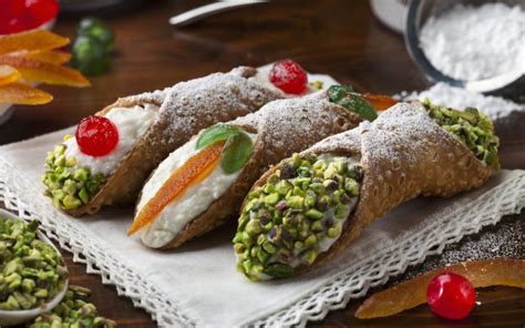 Dettaglio della decorazione di un cannolo siciliano con granella di pistacchio e arancia candita