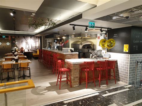 Interno di una pizzeria accogliente con tavoli apparecchiati