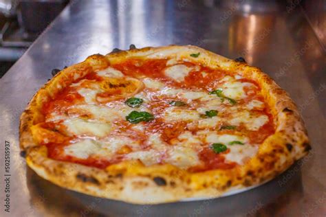 Pizza margherita appena sfornata con cornicione alto e soffice