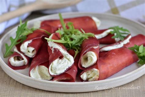 Involtini di tacchino e bresaola impiattati con insalata