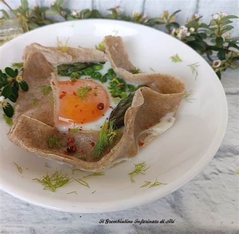 Composizione di un piatto con uovo fondente, cialda di pasta e basilico fritto