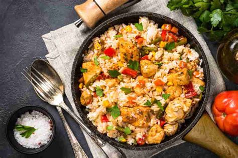 Immagine di un piatto di riso con pollo e verdure colorate